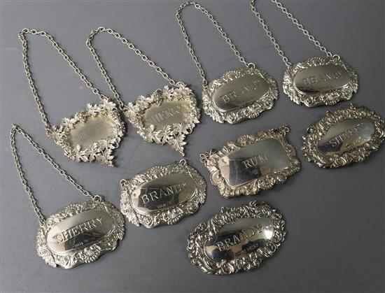 Nine assorted silver wine labels, including a set of four 1960s, a 1970s pair and a pair with vineous borders.